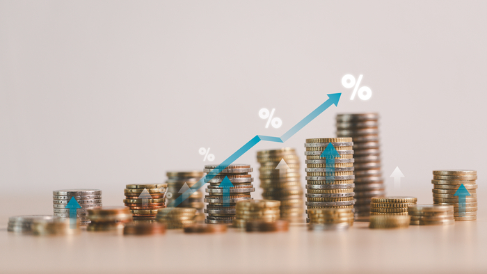 Rising stacks of coins with growth arrows and percentage symbols illustrating financial success, investment returns, economic growth and profit increase in business and money management concepts.